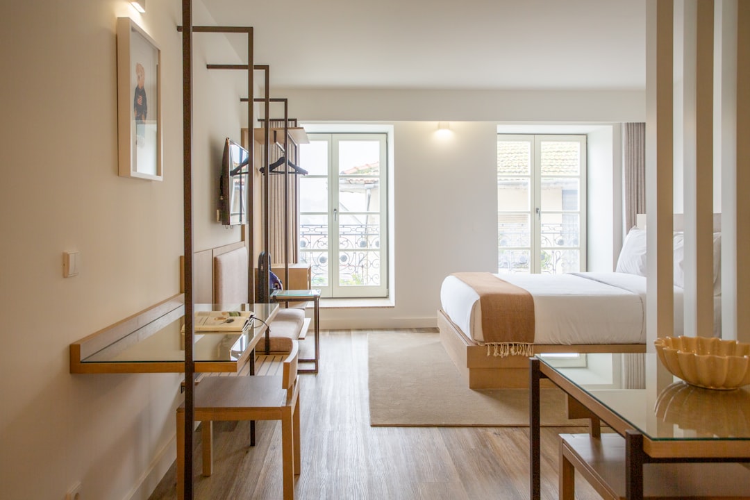 gallery-03 a-hotel-room-with-a-bed-desk-chairs-and-a-television-1ejxslufqu0